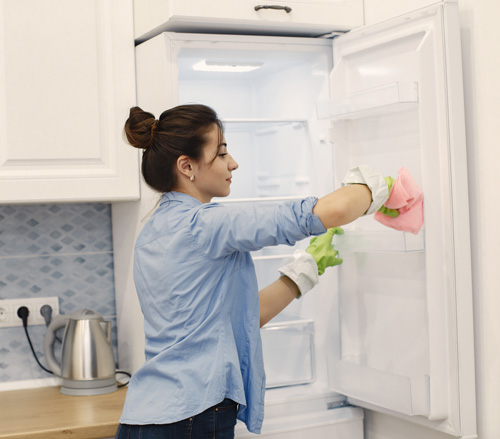 Mujer limpiando la cocina con bicarbonato de sodio