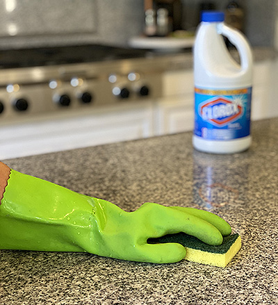 Persona limpiando encimera de la cocina con lejía